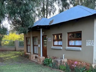 a small house with a blue roof at Legodimo Cottage in Dullstroom