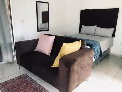 a couch with pillows on it in a living room at Uncle Charles Guesthouse in Pretoria
