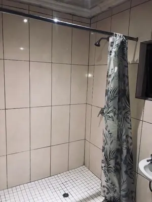 a shower with a shower curtain in a bathroom at Uncle Charles Guesthouse in Pretoria