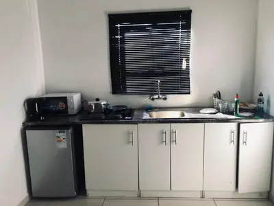 a small kitchen with a sink and a window at Uncle Charles Guesthouse in Pretoria