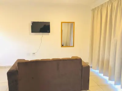 a living room with a couch and a mirror at Uncle Charles Guesthouse in Pretoria