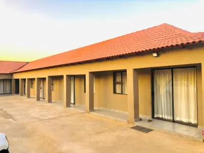 a yellow building with a red roof at Uncle Charles Guesthouse in Pretoria