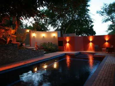 a swimming pool with lights in a backyard at night at Willow Inn in Nelspruit