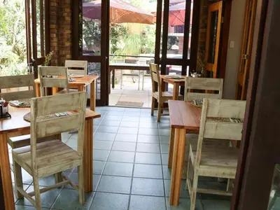 a dining room with wooden tables and chairs at Willow Inn in Nelspruit