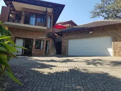 a brick house with a garage and a driveway at Willow Inn in Nelspruit
