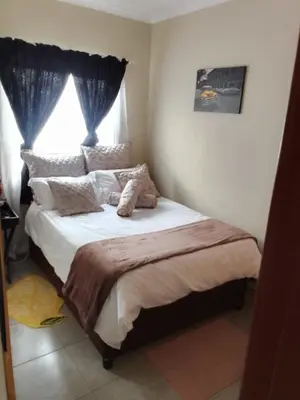 a bedroom with a large bed with a window at Corporate or Contractors Beautiful Aerorand Apartment in Middelburg