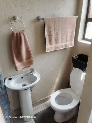 a bathroom with a toilet and a sink and towels at Corporate or Contractors Beautiful Aerorand Apartment in Middelburg