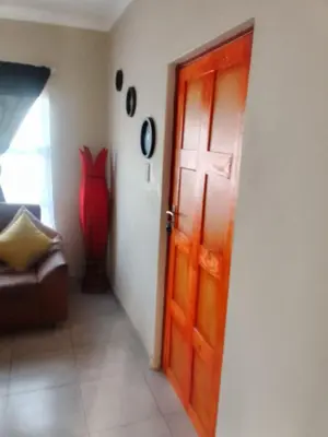 a room with a door and a couch and a red vase at Corporate or Contractors Beautiful Aerorand Apartment in Middelburg