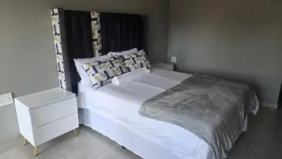 a bedroom with a white bed with a pillow at Backyard Stay in Pretoria