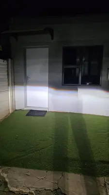a building with a field of grass next to a door at Backyard Stay in Pretoria