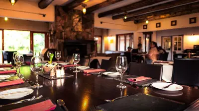 a table in a restaurant with wine glasses on it at Riverbend on Komati in Machadodorp