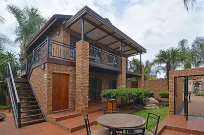 a house with a balcony and a patio at Africa House Guesthouse in Centurion