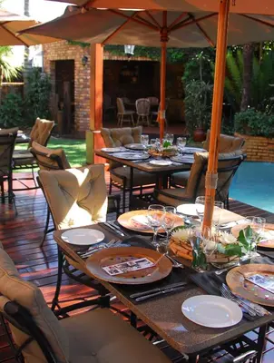 a table set up for a meal on a patio at Africa House Guesthouse in Centurion