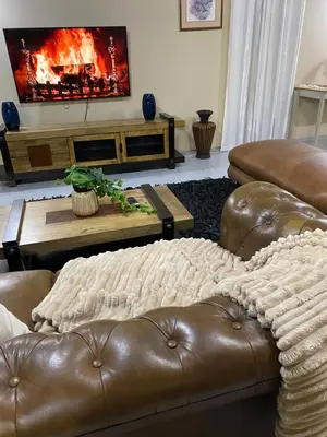 a living room with two leather couches and a fireplace at Serene Exclusive Country Retreat in White River