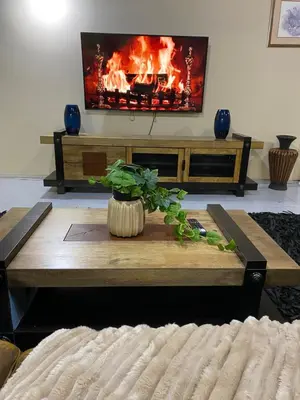 a living room with a table with a fire in the background at Serene Exclusive Country Retreat in White River