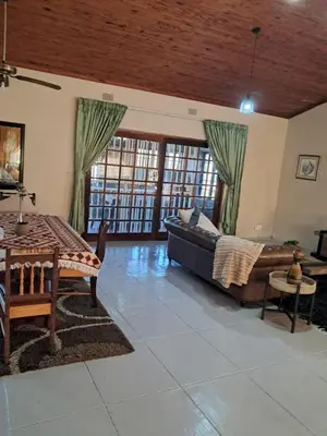 a living room with a couch and a table at Serene Exclusive Country Retreat in White River