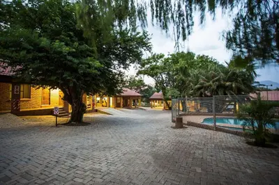 a courtyard with a tree and a swimming pool at Phabema Guest House in Steelpoort