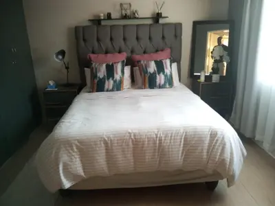 a bedroom with a large white bed with pink pillows at Simply Stay in Polokwane