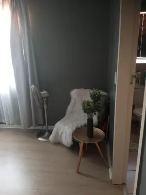 a room with a chair and a table with a plant at Simply Stay in Polokwane