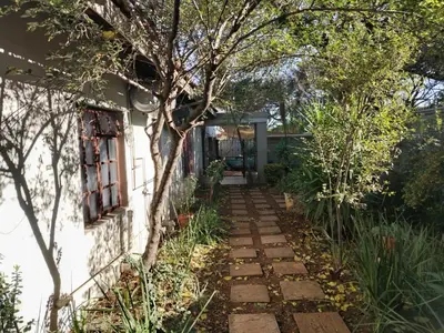 a garden path leading to a house at Faerie Glen B&B in Pretoria