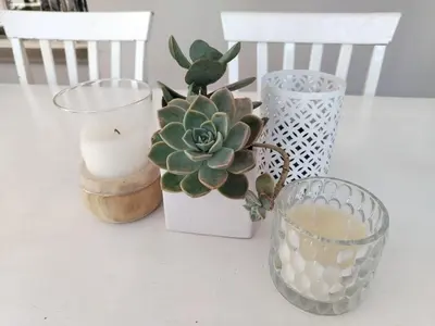 a table with three vases and a candle and a cactus at Faerie Glen B&B in Pretoria