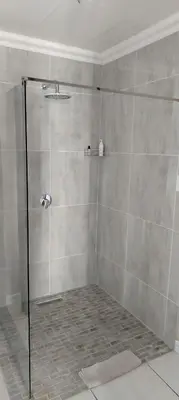 a shower with a glass door in a bathroom at Faerie Glen B&B in Pretoria