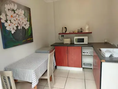 a small kitchen with a table and a microwave at Faerie Glen B&B in Pretoria