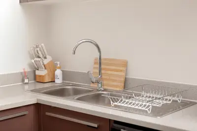 a kitchen sink with a dish drying rack on it at Closer to Home Luxury Apartments in Midrand
