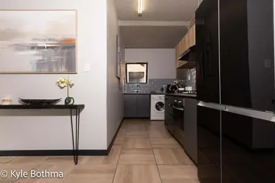 a kitchen with a counter and a table in it at Smart Apartment Luxury in Midrand