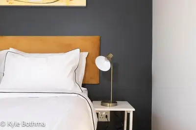 a bedroom with a bed and a lamp on a table at Smart Apartment Luxury in Midrand