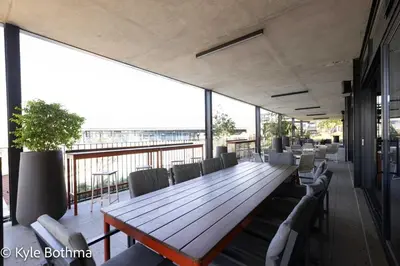 a large wooden table and chairs on a balcony at Smart Apartment Luxury in Midrand