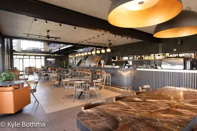 a restaurant with tables and chairs and a bar at Smart Apartment Luxury in Midrand