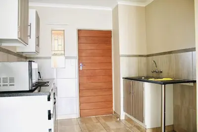 a kitchen with a wooden door and a kitchen counter at Capital Heights in Pretoria