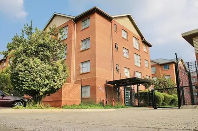 a brick building with a car parked in front of it at Capital Heights in Pretoria
