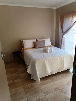 a bedroom with a bed with a teddy bear on it at Capital Heights in Pretoria
