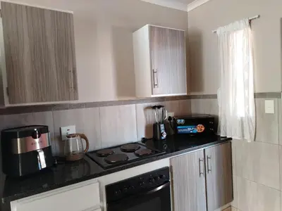 a small kitchen with a stove and a microwave at Capital Heights in Pretoria