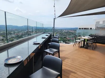 a balcony with tables and chairs on a building at The Regal Studio at The Capital Trilogy in Pretoria