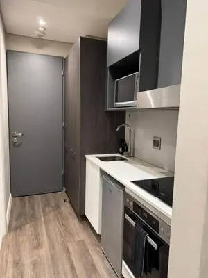 a kitchen with a sink and a stove and a door at The Regal Studio at The Capital Trilogy in Pretoria