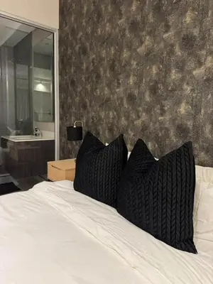 a bedroom with a bed with two pillows on it at The Regal Studio at The Capital Trilogy in Pretoria