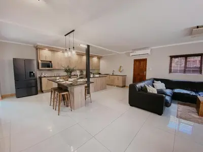 a living room and kitchen with a couch and a table at Sable Block Self-Catering in Musina