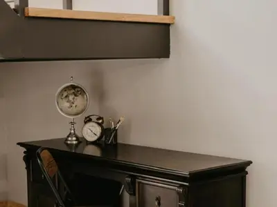 a wooden desk with a clock and a mirror at Sable Block Self-Catering in Musina