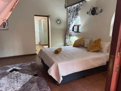 a bedroom with a bed with yellow pillows at Little Africa in Midrand in Randjesfontein