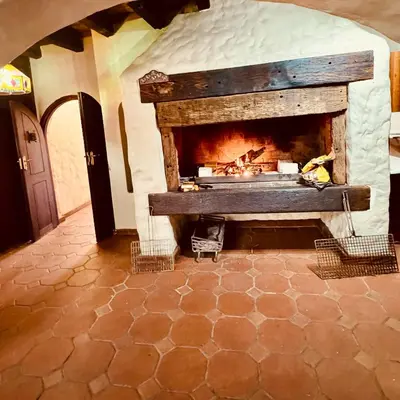 a stone fireplace in a room with a fire at Little Africa in Midrand in Randjesfontein
