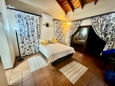 a bedroom with a bed with yellow pillows on it at Little Africa in Midrand in Randjesfontein