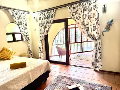 a bedroom with a bed and a sliding glass door at Little Africa in Midrand in Randjesfontein