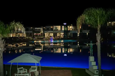 a hotel swimming pool at night with a statue next to it at THE BLYDE CRYSTAL LAGOON F&S LUxurious Apartment 3bed in Pretoria