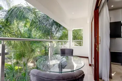 a glass table and chairs in a room with a large window at The Diplomat in Midrand