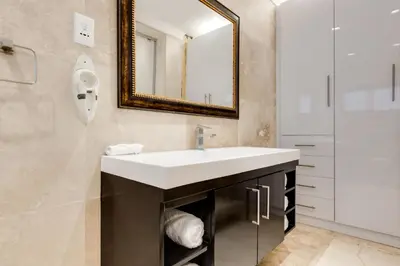 a bathroom with a sink and a mirror at The Diplomat in Midrand