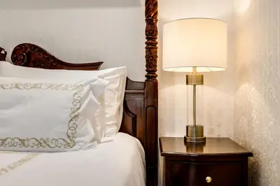 a bedroom with a bed with a lamp on a night stand at The Diplomat in Midrand
