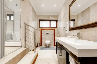 a bathroom with a sink and a tub and a toilet at The Diplomat in Midrand